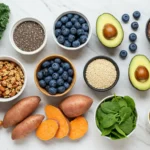 A healthy selection of nutrient-dense foods, including sweet potatoes, spinach, avocados, chia, and fruits like blueberries. Ideal for a balanced diet.